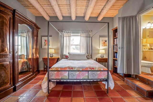 bedroom with beamed ceiling, wood ceiling, and connected bathroom