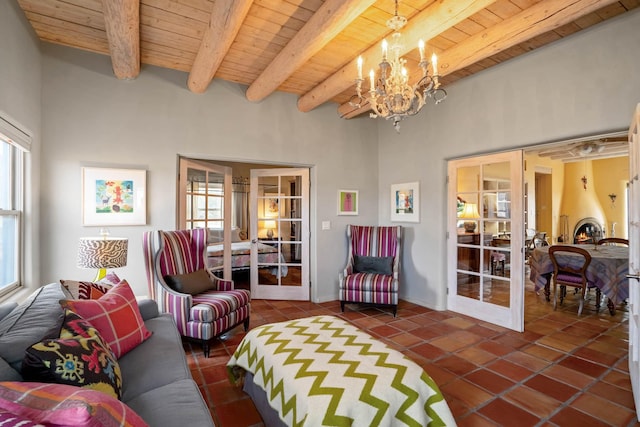 tiled living room featuring a notable chandelier, beam ceiling, french doors, and wooden ceiling