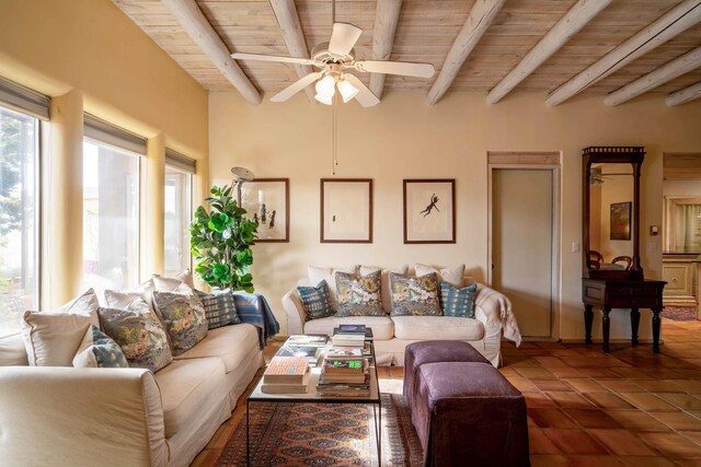 living room with beamed ceiling, ceiling fan, and wood ceiling