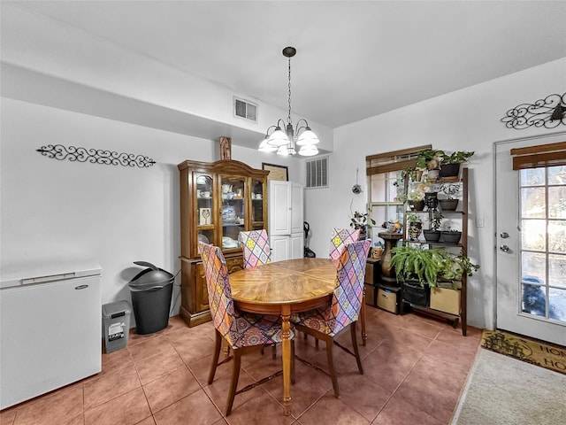 tiled dining room featuring a chandelier