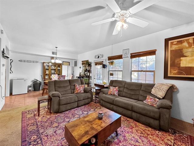 living room with light carpet and ceiling fan with notable chandelier