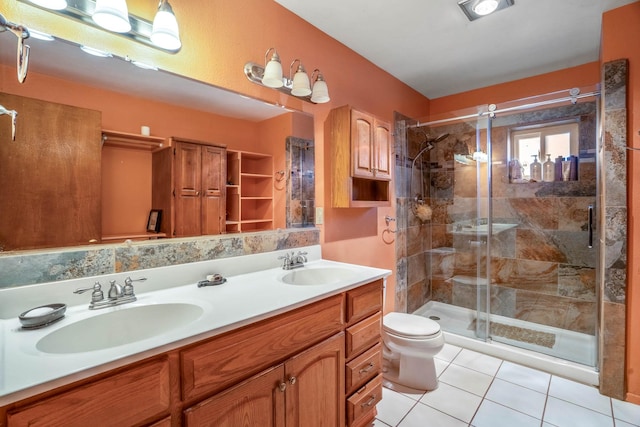 bathroom featuring tile patterned floors, vanity, toilet, and a shower with shower door