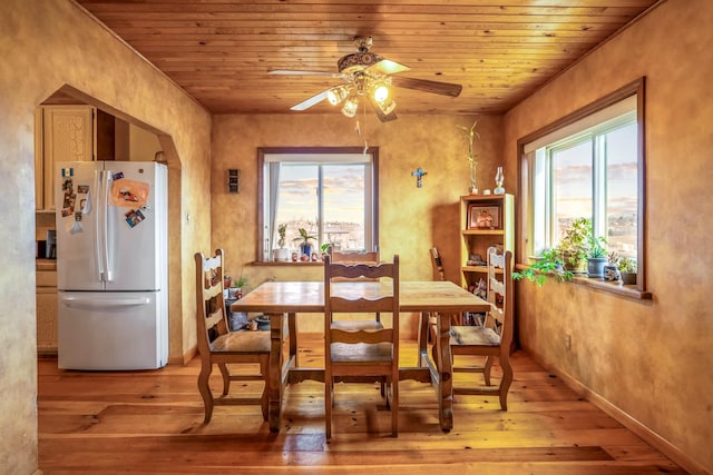 dining room with light hardwood / wood-style flooring, ceiling fan, and wood ceiling