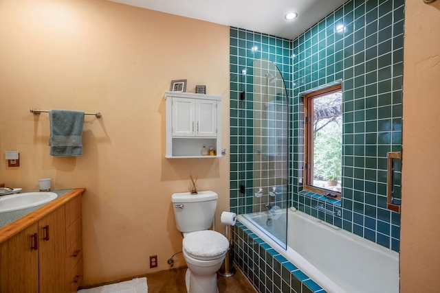 full bathroom featuring vanity, tiled shower / bath combo, and toilet