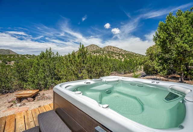 view of pool featuring a deck with mountain view and a hot tub