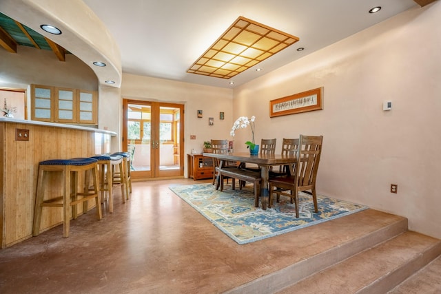 dining space featuring concrete flooring and french doors