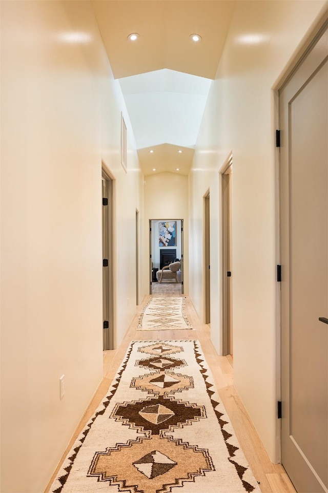 hall featuring a towering ceiling and light hardwood / wood-style floors