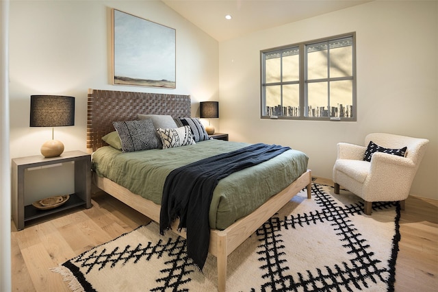 bedroom with light hardwood / wood-style flooring and lofted ceiling