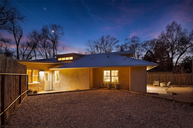 back house at dusk with a patio