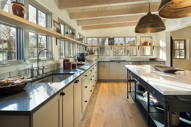 kitchen featuring light wood-type flooring, sink, wooden ceiling, vaulted ceiling with beams, and white cabinetry