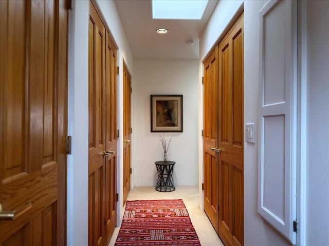 hall featuring a skylight and light carpet