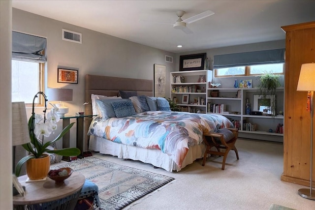 carpeted bedroom with ceiling fan and multiple windows