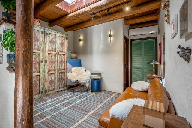 sitting room featuring beam ceiling, a wall mounted AC, a skylight, and wooden ceiling