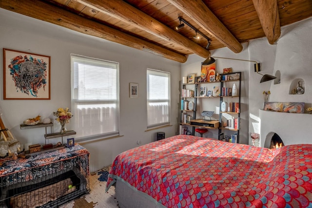 bedroom with beamed ceiling, wood ceiling, and rail lighting