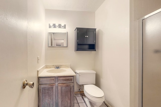 bathroom featuring vanity, tile patterned flooring, toilet, a textured ceiling, and a shower with shower door