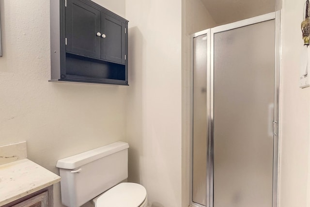 bathroom featuring vanity, toilet, and walk in shower