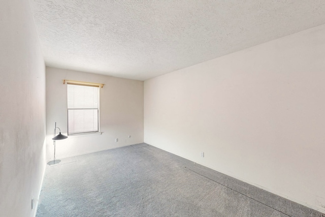 empty room with a textured ceiling and carpet floors