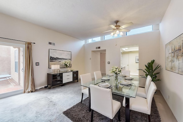 dining room with carpet, ceiling fan, a high ceiling, and a wealth of natural light