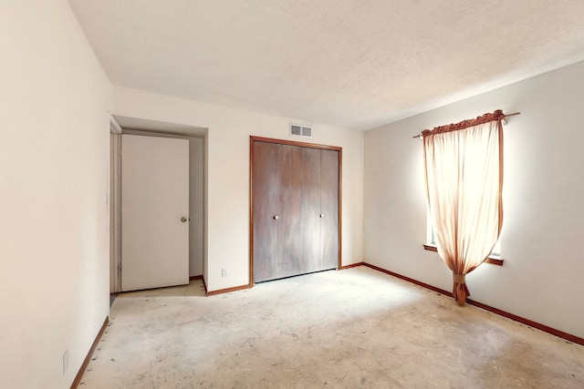 unfurnished bedroom featuring a textured ceiling and a closet