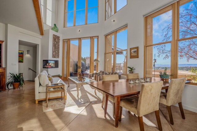 dining area featuring a high ceiling and concrete flooring