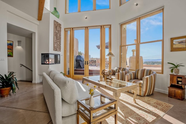 living room with a high ceiling and concrete floors