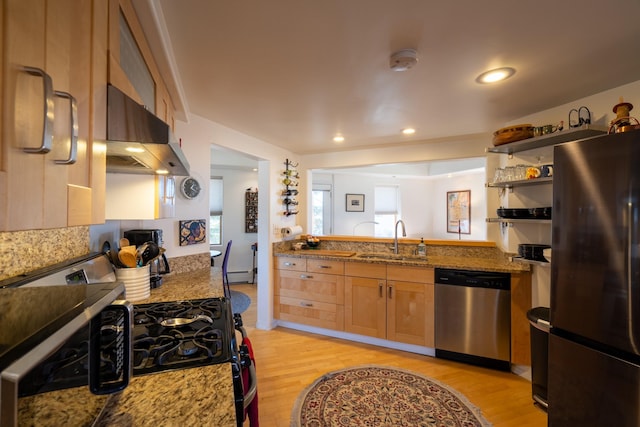 kitchen featuring refrigerator, dishwasher, light hardwood / wood-style floors, dark stone countertops, and sink