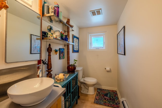 bathroom with toilet, vanity, and hardwood / wood-style floors