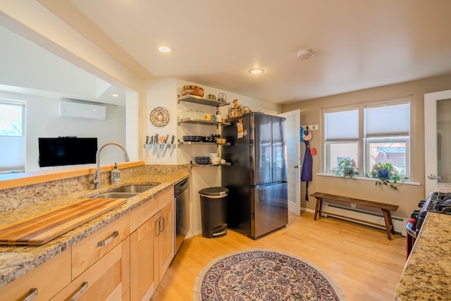 kitchen with sink, light brown cabinets, light hardwood / wood-style floors, baseboard heating, and appliances with stainless steel finishes