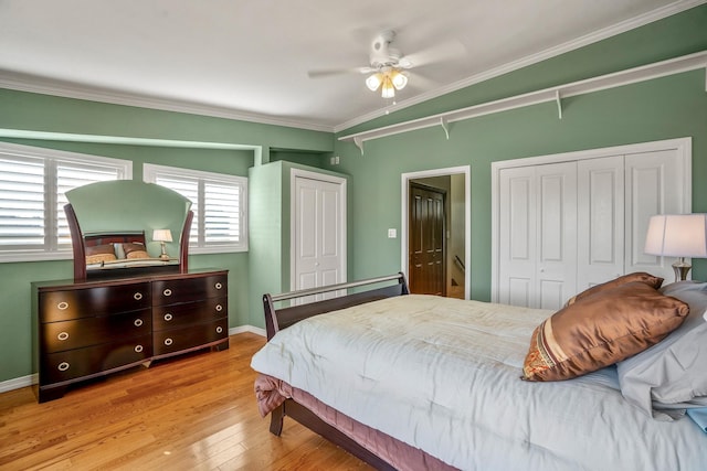 bedroom with crown molding, two closets, ceiling fan, and light hardwood / wood-style flooring