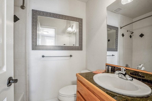 bathroom featuring toilet, a tile shower, and vanity