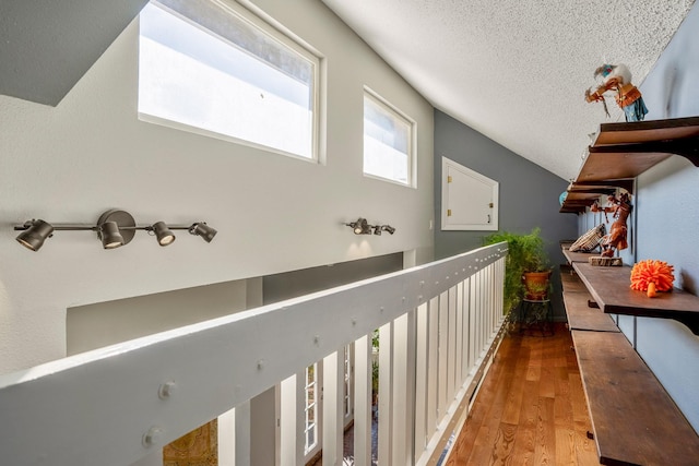 hall with a textured ceiling and hardwood / wood-style flooring