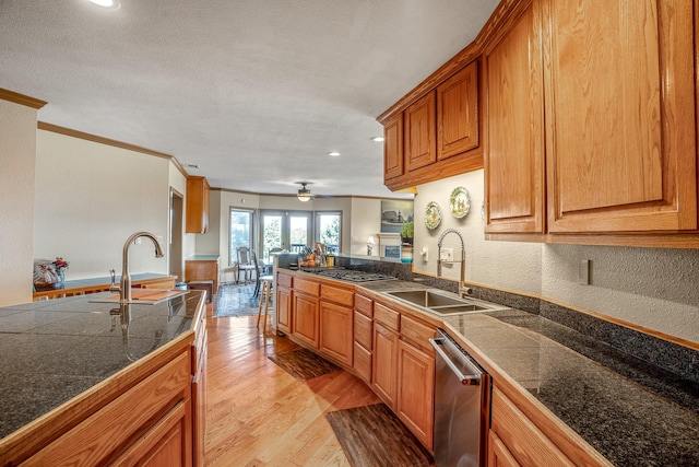 kitchen featuring stainless steel appliances, light hardwood / wood-style floors, crown molding, ceiling fan, and sink