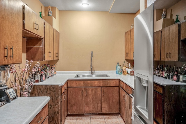 kitchen with sink, stainless steel refrigerator with ice dispenser, and light tile patterned floors