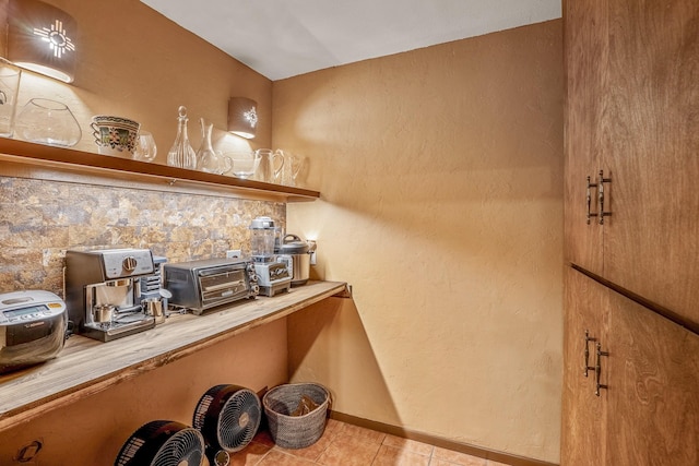 bar with light tile patterned floors and backsplash