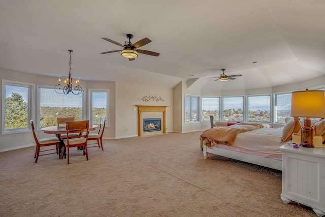 bedroom featuring ceiling fan with notable chandelier, light colored carpet, and lofted ceiling