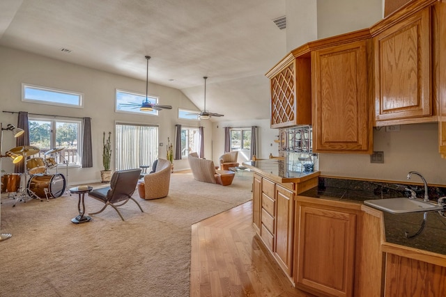 kitchen with sink, decorative light fixtures, ceiling fan, and light hardwood / wood-style floors