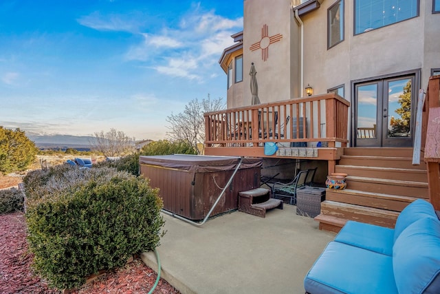 patio terrace at dusk with a hot tub and french doors