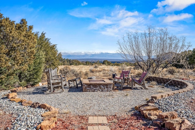 view of yard with an outdoor fire pit and a mountain view