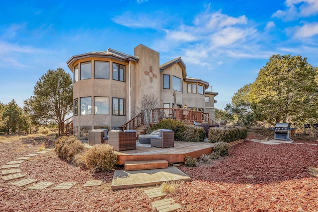 rear view of property featuring a deck and an outdoor living space