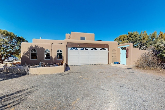 pueblo revival-style home with a garage