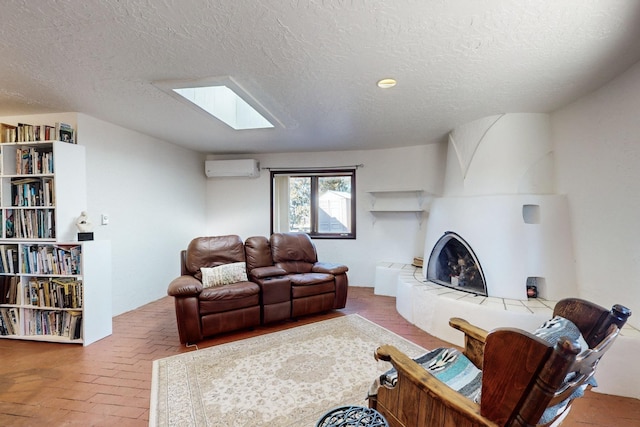 living room featuring a tile fireplace, a textured ceiling, and a wall unit AC