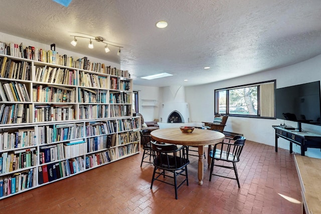 dining room featuring a large fireplace and a textured ceiling