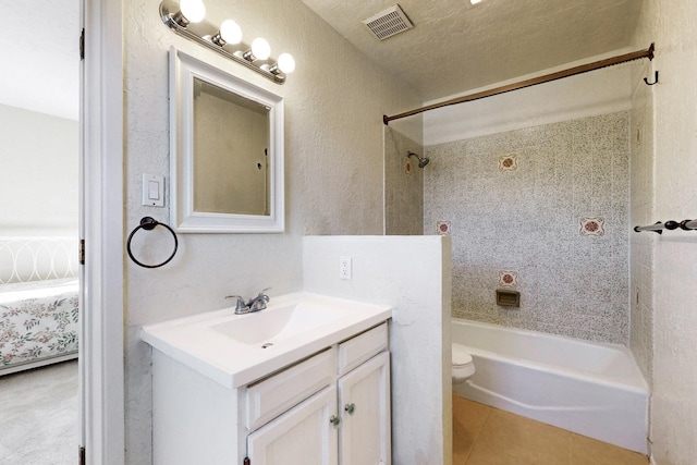 full bathroom with toilet, vanity, tile patterned floors, and tiled shower / bath combo