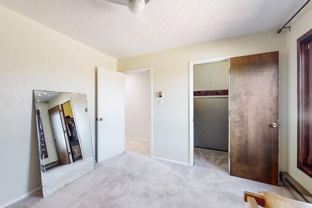 carpeted bedroom featuring a walk in closet, a closet, and a textured ceiling