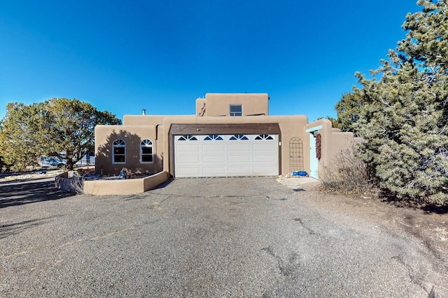 pueblo-style house with a garage