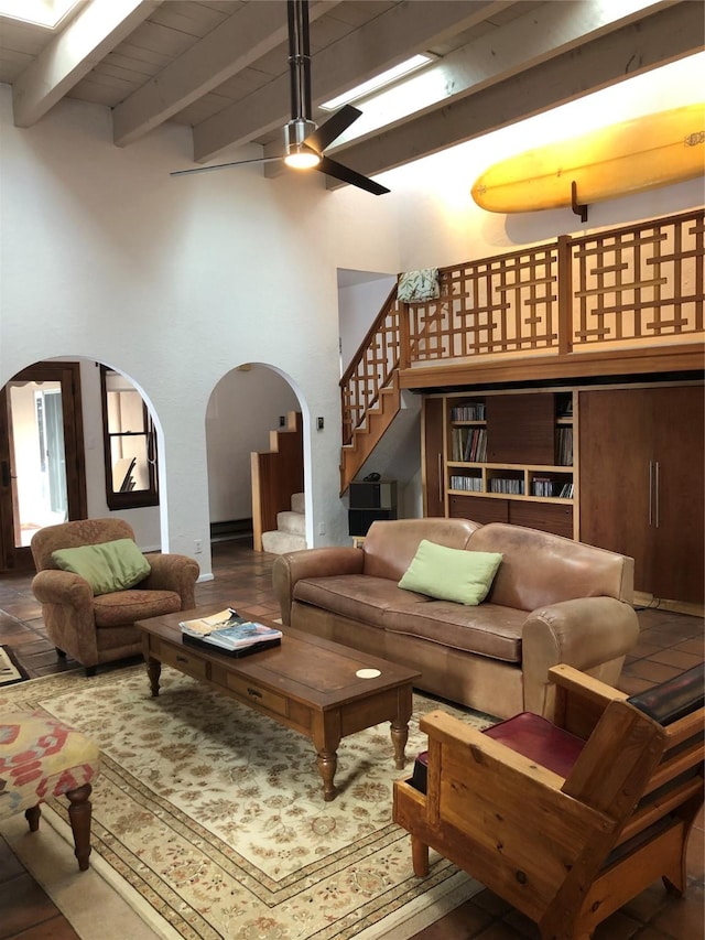 living room with ceiling fan and beamed ceiling