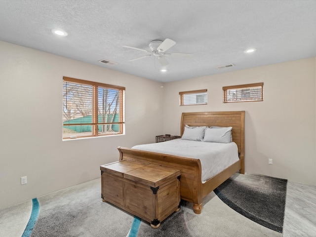 carpeted bedroom featuring a textured ceiling and ceiling fan