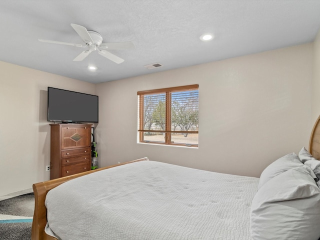 carpeted bedroom with a textured ceiling and ceiling fan