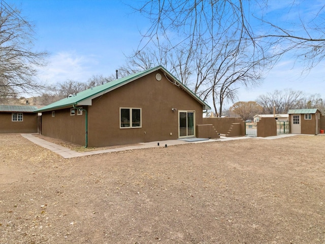 rear view of house featuring a storage unit