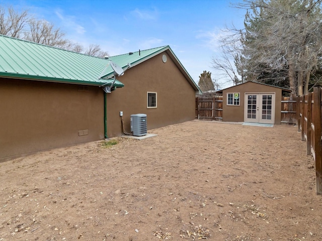 rear view of house featuring central AC and an outbuilding